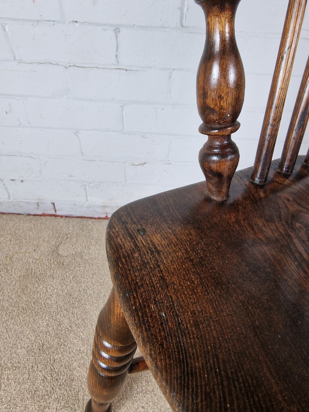A 19th-century dark wooden Lincolnshire Windsor armchair featuring a hoop back, central pierced splat, turned spindles, and turned legs. View IX