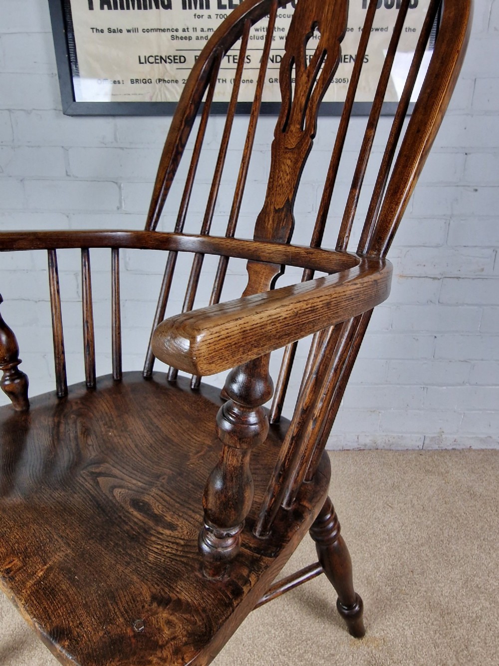 A 19th-century dark wooden Lincolnshire Windsor armchair featuring a hoop back, central pierced splat, turned spindles, and turned legs. View X
