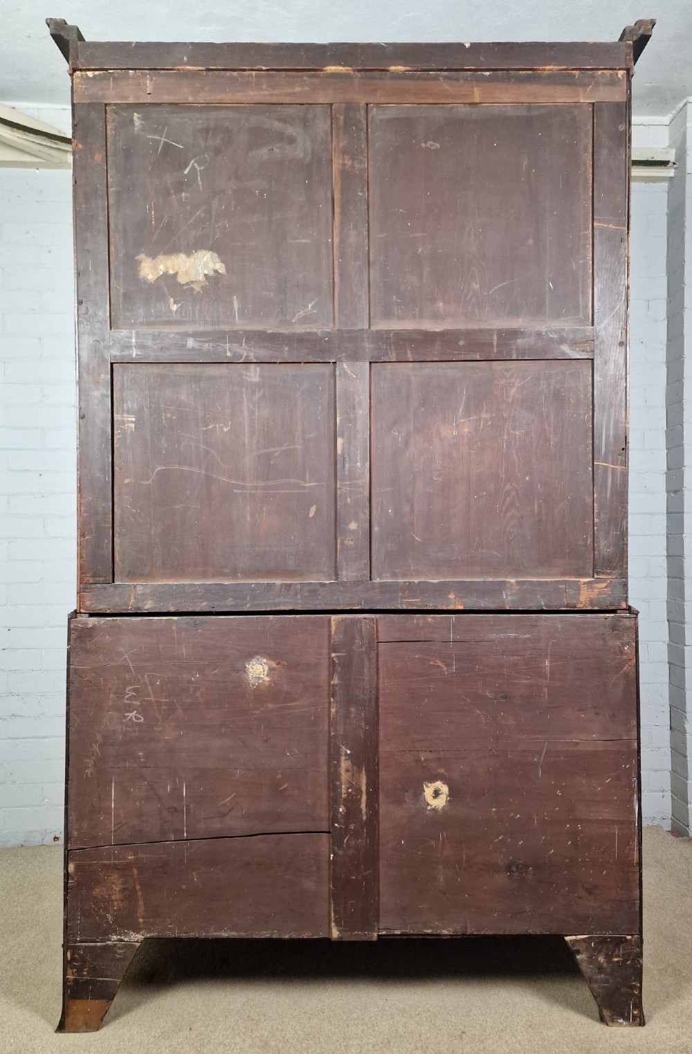 An early nineteenth-century George IV flame mahogany linen press featuring a double-door upper cupboard over a chest of drawers with bracket feet. View VII