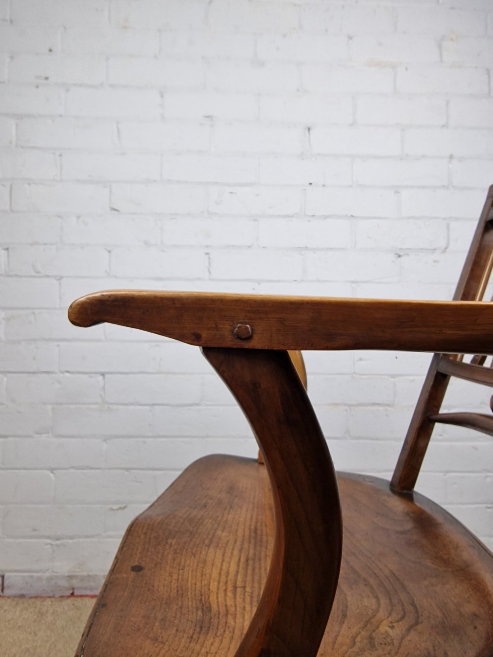 A mid-19th-century wooden Mendlesham armchair featuring a squared backrest with turned wooden spheres, pierced splats, curved arms, and a shaped seat on turned legs. View II