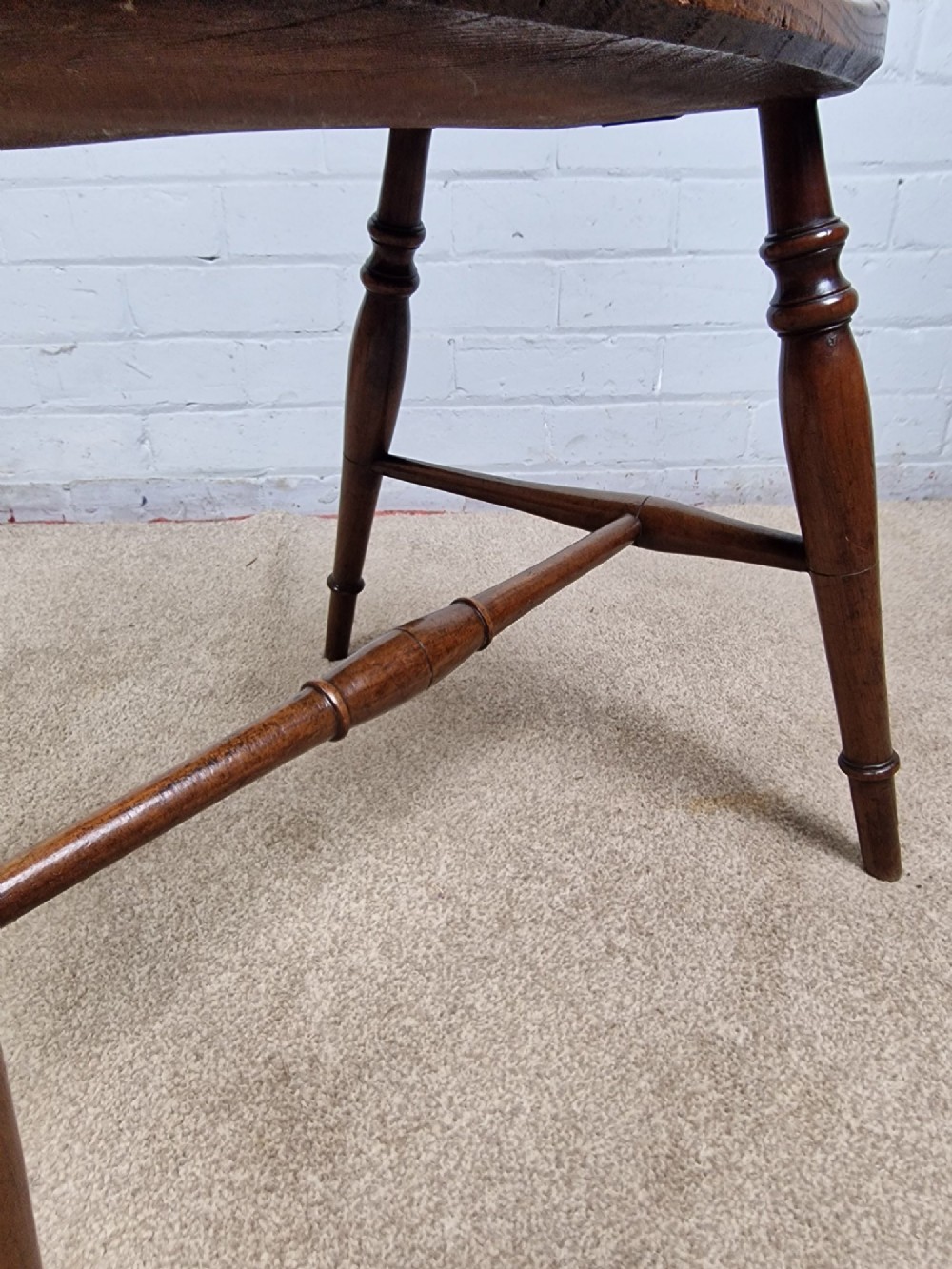 A mid-19th-century wooden Mendlesham armchair featuring a squared backrest with turned wooden spheres, pierced splats, curved arms, and a shaped seat on turned legs. View VI