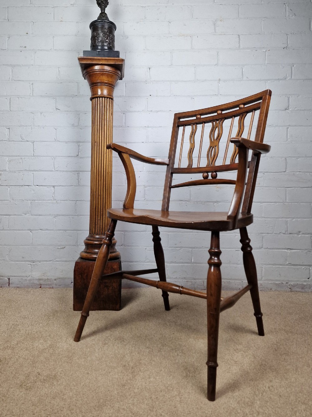 A mid-19th-century wooden Mendlesham armchair featuring a squared backrest with turned wooden spheres, pierced splats, curved arms, and a shaped seat on turned legs. View VIII