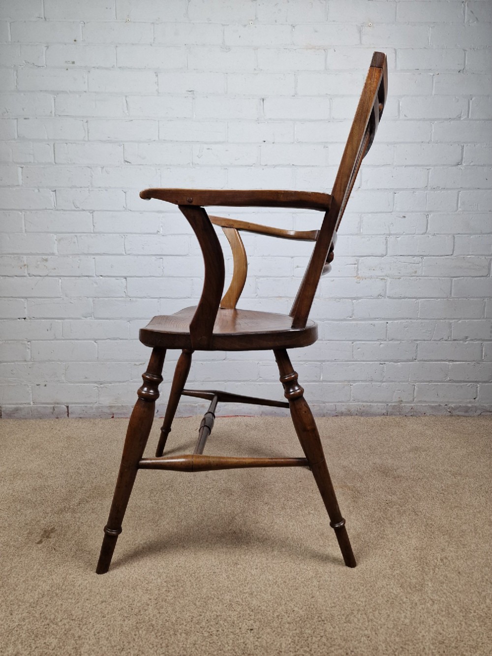A mid-19th-century wooden Mendlesham armchair featuring a squared backrest with turned wooden spheres, pierced splats, curved arms, and a shaped seat on turned legs. View XIII