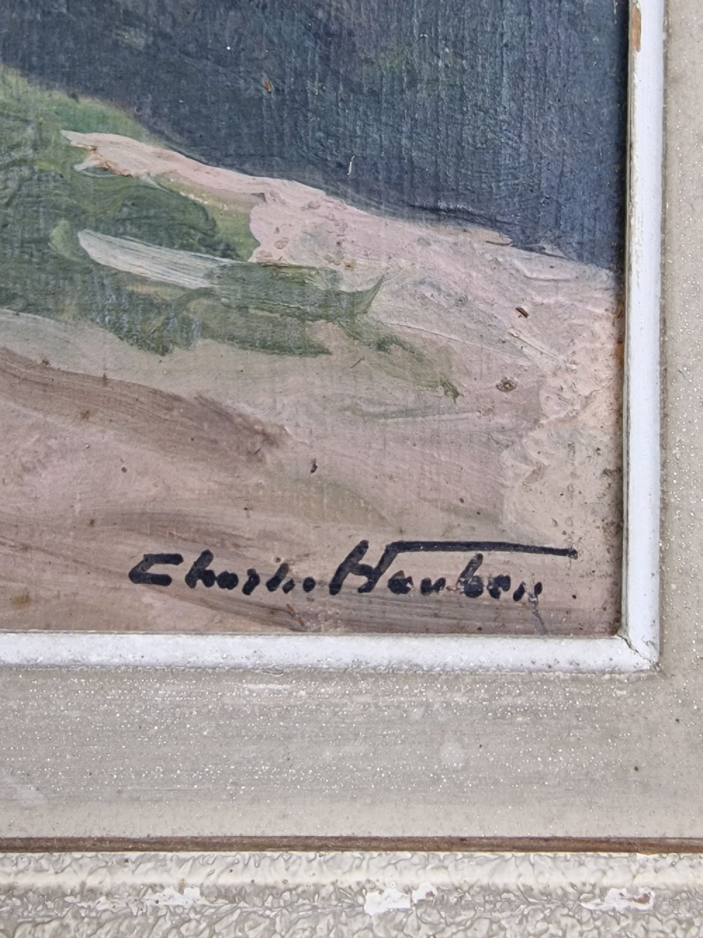 An oil painting on board depicting a Belgian farmyard scene with whitewashed cottages and trees, housed in a wide off-white molded frame. View VII