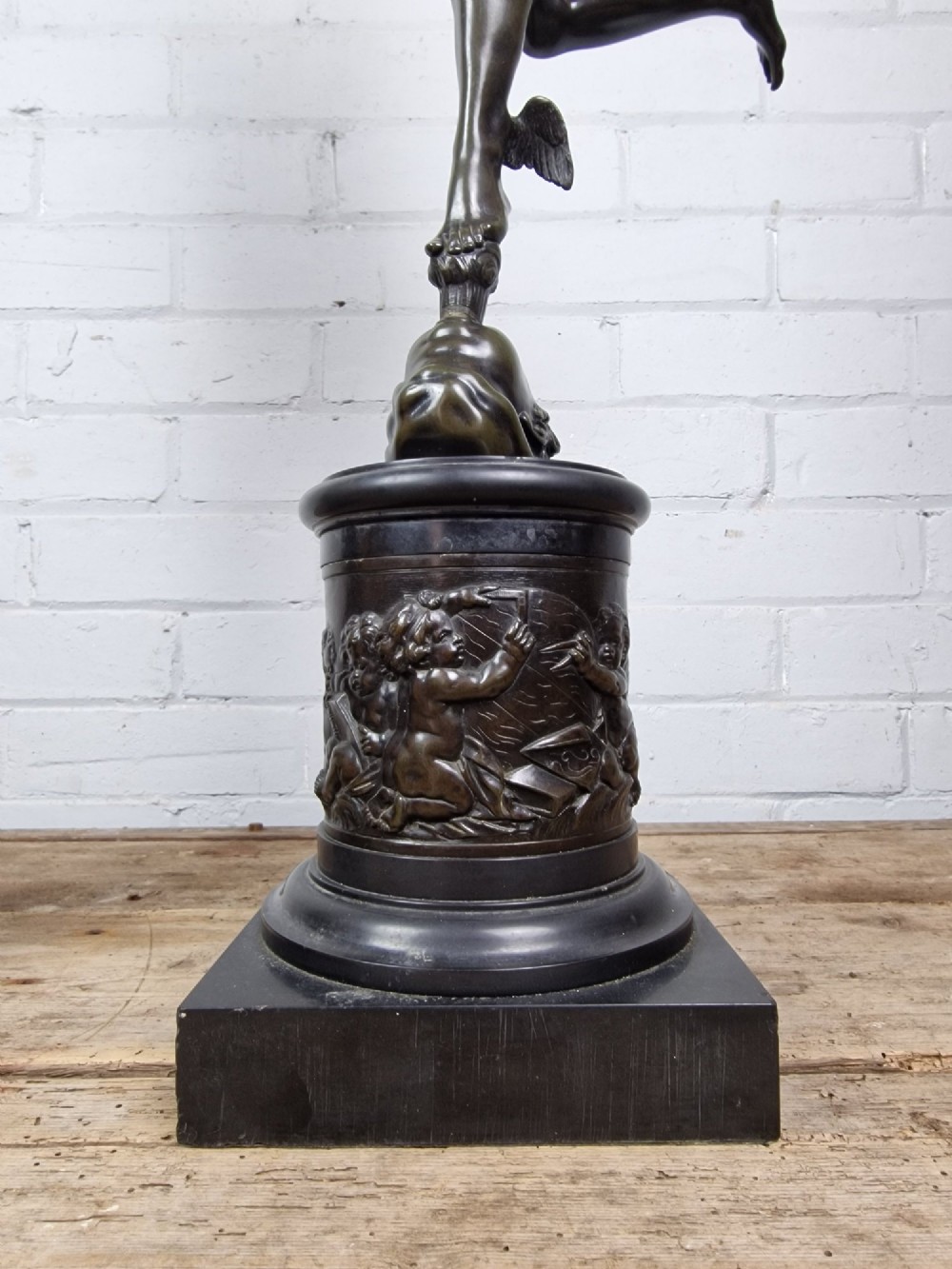 A pair of late 19th-century patinated dark bronze classical figures depicting Mercury and Fortuna, mounted on relief-decorated cylindrical pedestals and square black bases. View II
