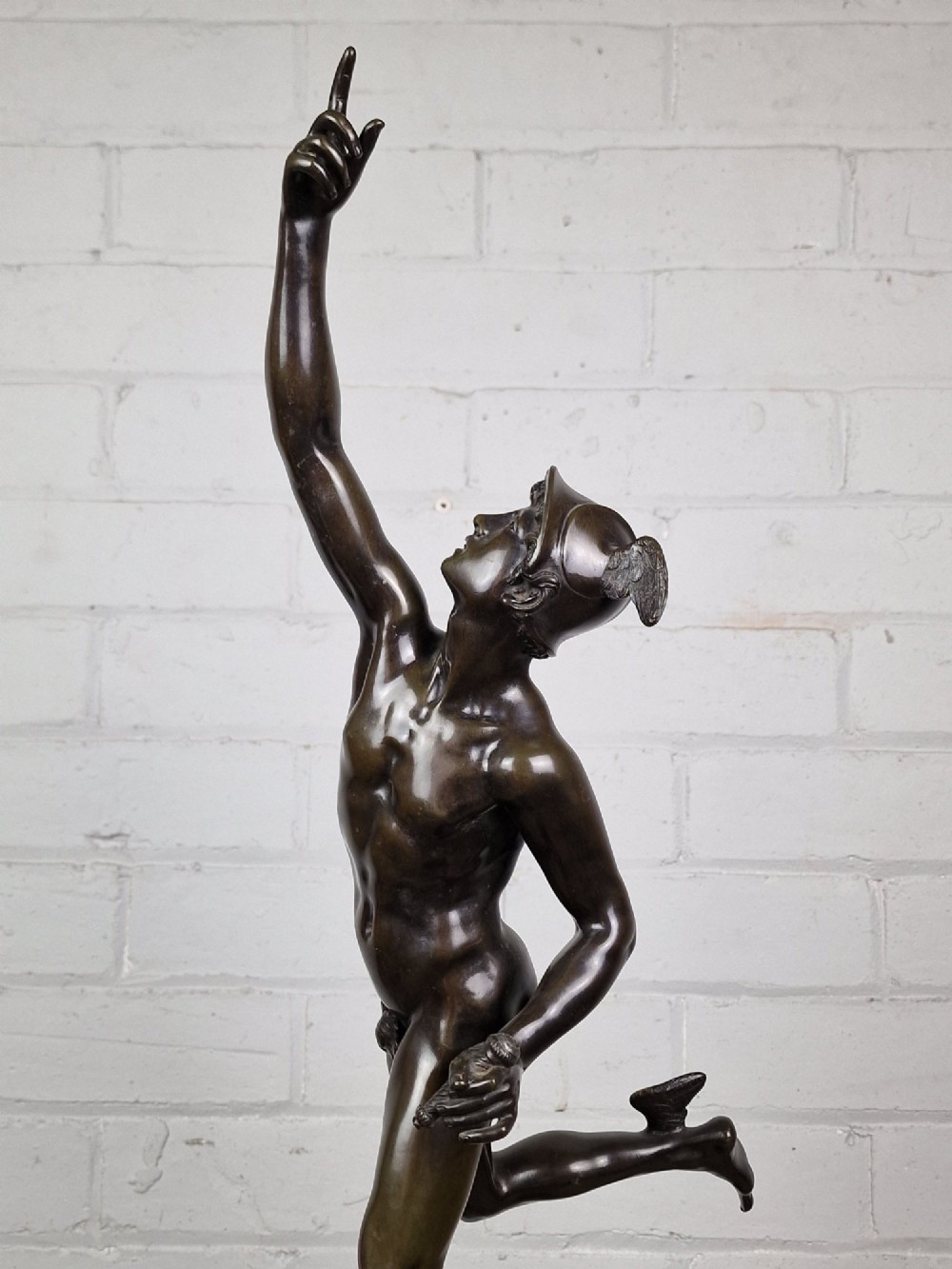 A pair of late 19th-century patinated dark bronze classical figures depicting Mercury and Fortuna, mounted on relief-decorated cylindrical pedestals and square black bases. View VI