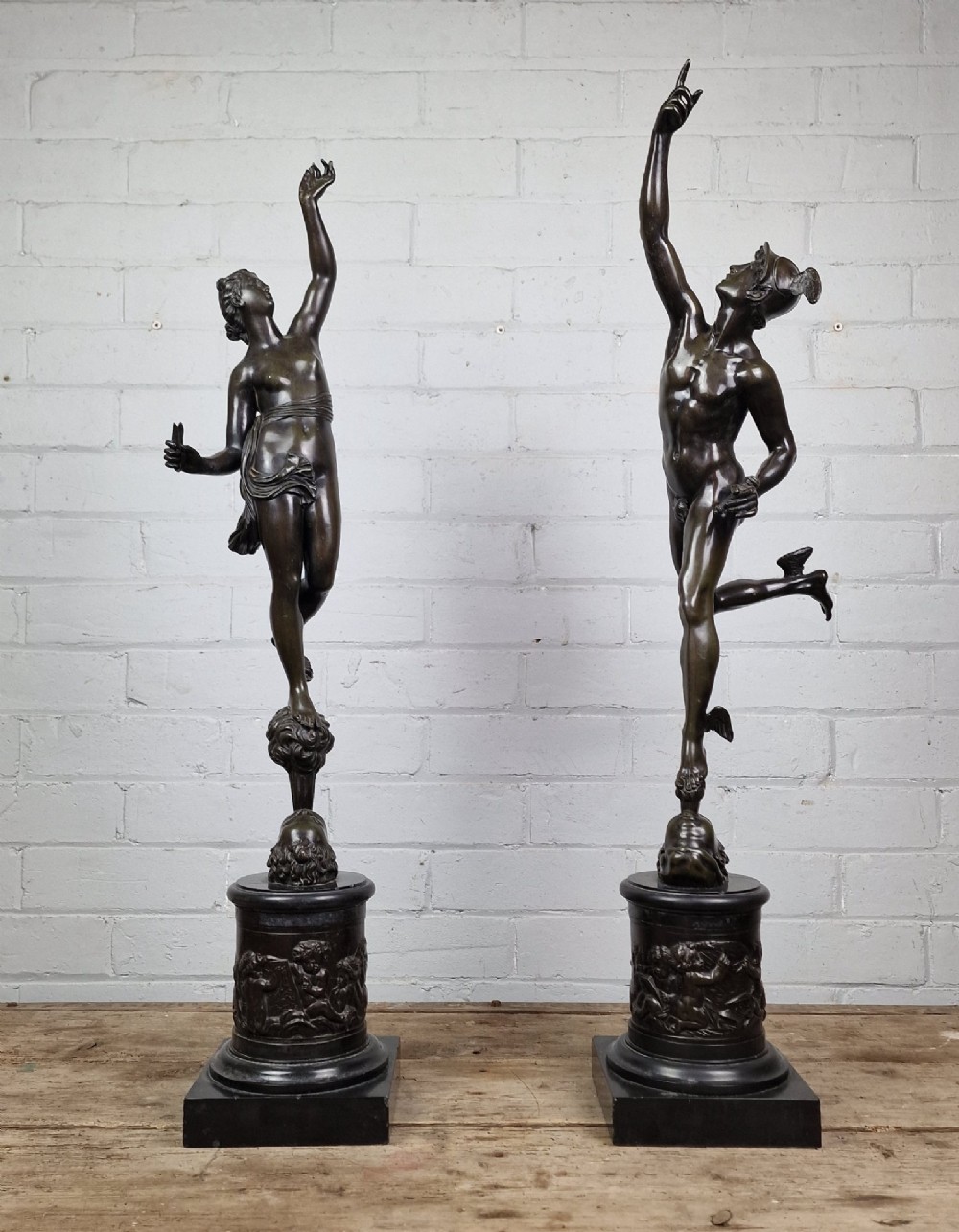 A pair of late 19th-century patinated dark bronze classical figures depicting Mercury and Fortuna, mounted on relief-decorated cylindrical pedestals and square black bases. View X