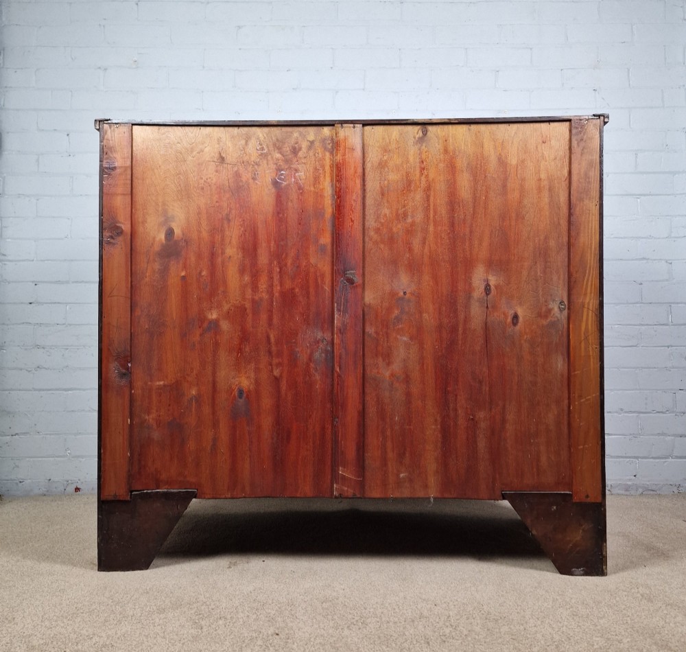 A George III mahogany bowfront chest of drawers featuring two short over three long graduating drawers with brass handles and splay bracket feet. View IX
