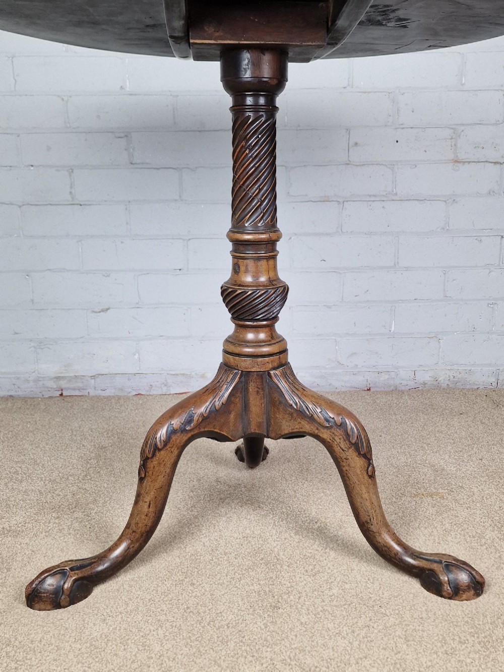 An 18th-century George II walnut tilt-top table featuring a circular top resting on a spiral-twisted column, carved cabriole legs, and claw and ball feet. View II