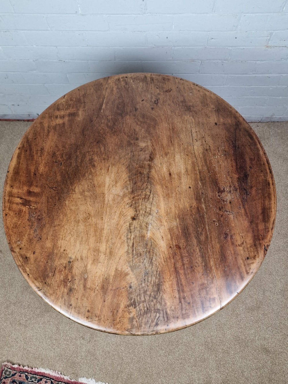 An 18th-century George II walnut tilt-top table featuring a circular top resting on a spiral-twisted column, carved cabriole legs, and claw and ball feet. View III