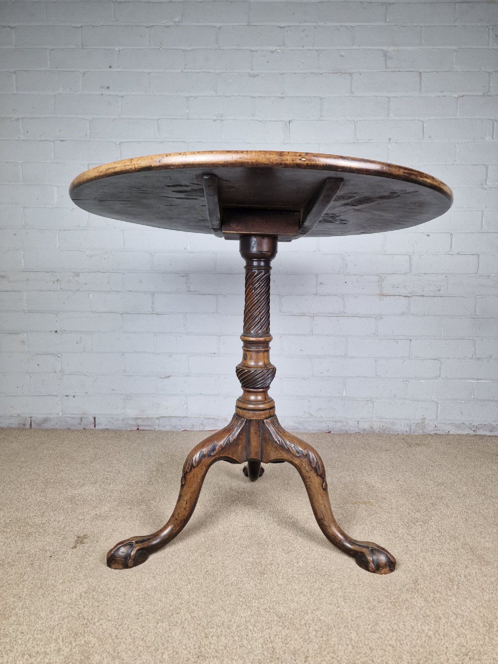 An 18th-century George II walnut tilt-top table featuring a circular top resting on a spiral-twisted column, carved cabriole legs, and claw and ball feet. View IX