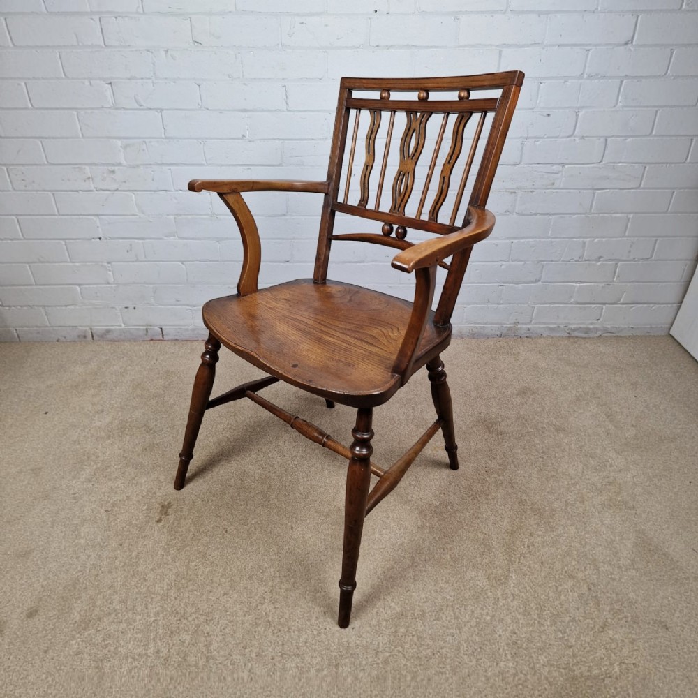 A mid-19th-century wooden Mendlesham armchair featuring a squared backrest with turned wooden spheres, pierced splats, curved arms, and a shaped seat on turned legs. View III