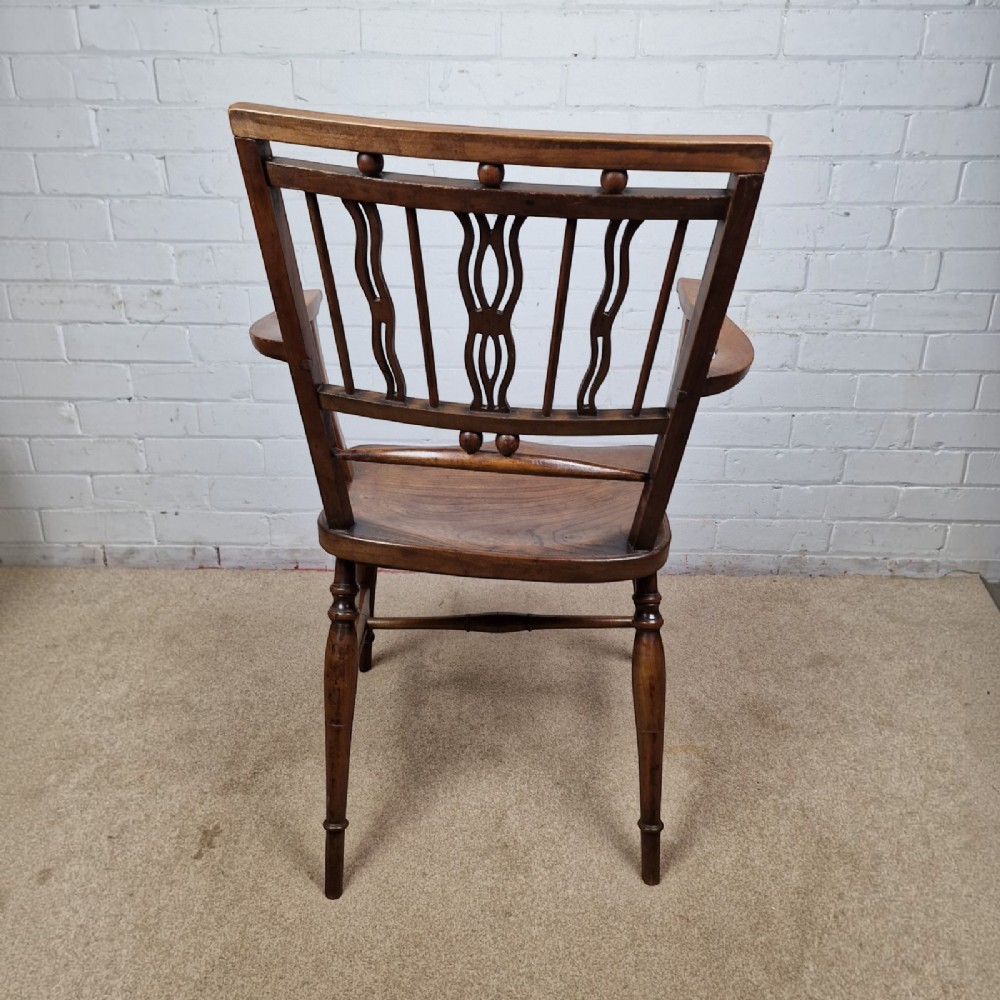 A mid-19th-century wooden Mendlesham armchair featuring a squared backrest with turned wooden spheres, pierced splats, curved arms, and a shaped seat on turned legs. View VI