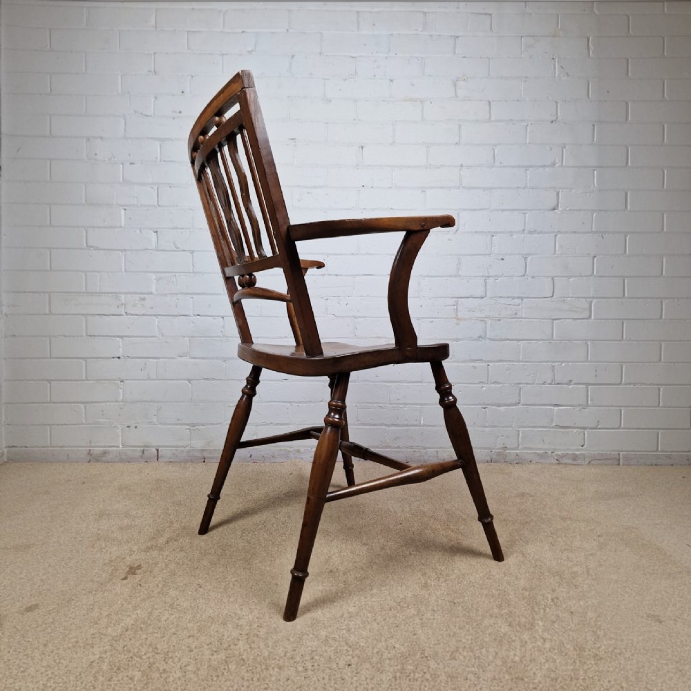 A mid-19th-century wooden Mendlesham armchair featuring a squared backrest with turned wooden spheres, pierced splats, curved arms, and a shaped seat on turned legs. View VII