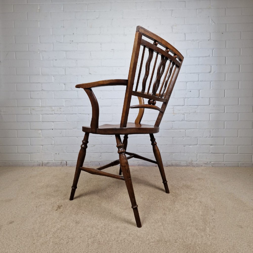 A mid-19th-century wooden Mendlesham armchair featuring a squared backrest with turned wooden spheres, pierced splats, curved arms, and a shaped seat on turned legs. View VIII