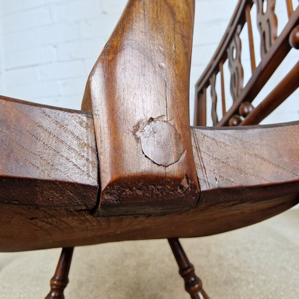 A mid-19th-century wooden Mendlesham armchair featuring a squared backrest with turned wooden spheres, pierced splats, curved arms, and a shaped seat on turned legs. View X