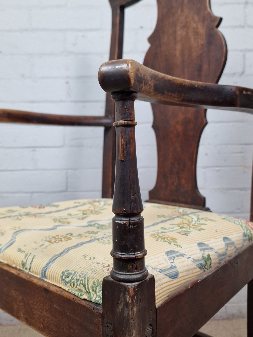 A late eighteenth-century dark oak armchair featuring a vase-shaped splat back, turned arm supports, and a patterned floral fabric drop-in seat. View III