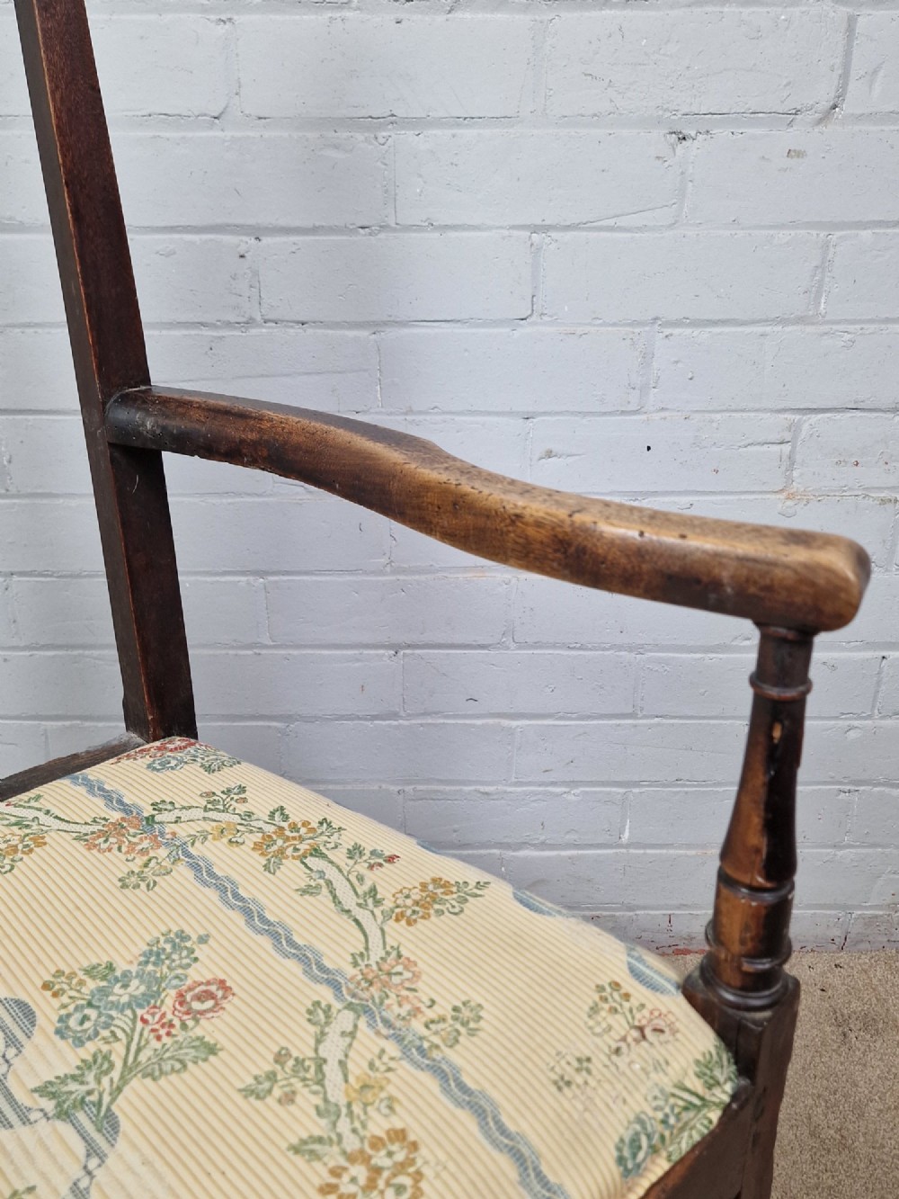 A late eighteenth-century dark oak armchair featuring a vase-shaped splat back, turned arm supports, and a patterned floral fabric drop-in seat. View IX