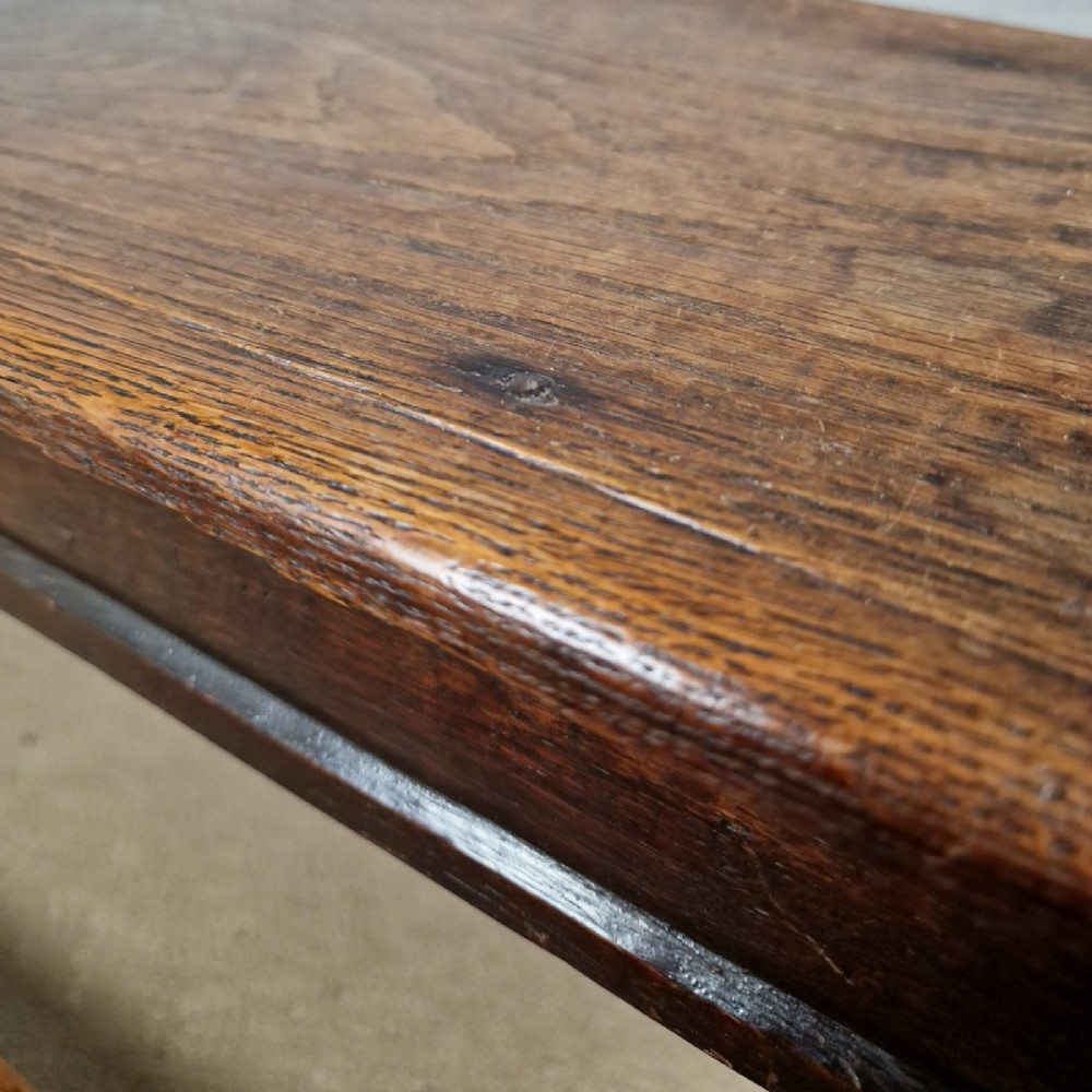 An 18th-century dark oak long stool featuring four barley twist legs connected by low stretchers beneath a solid rectangular top. View V