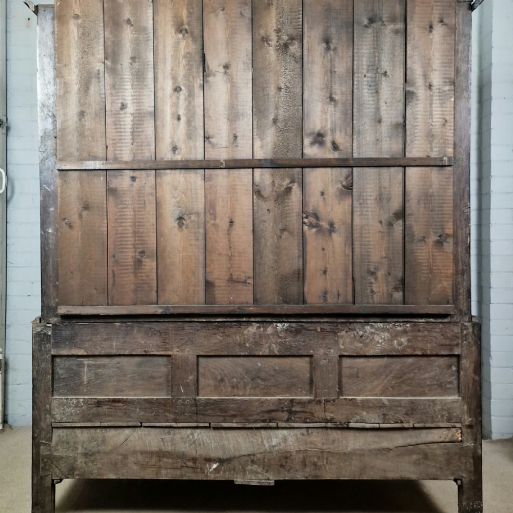 A mid-18th-century dark oak Georgian livery cupboard featuring raised panel doors, brass fittings, and lower drawers. View IX