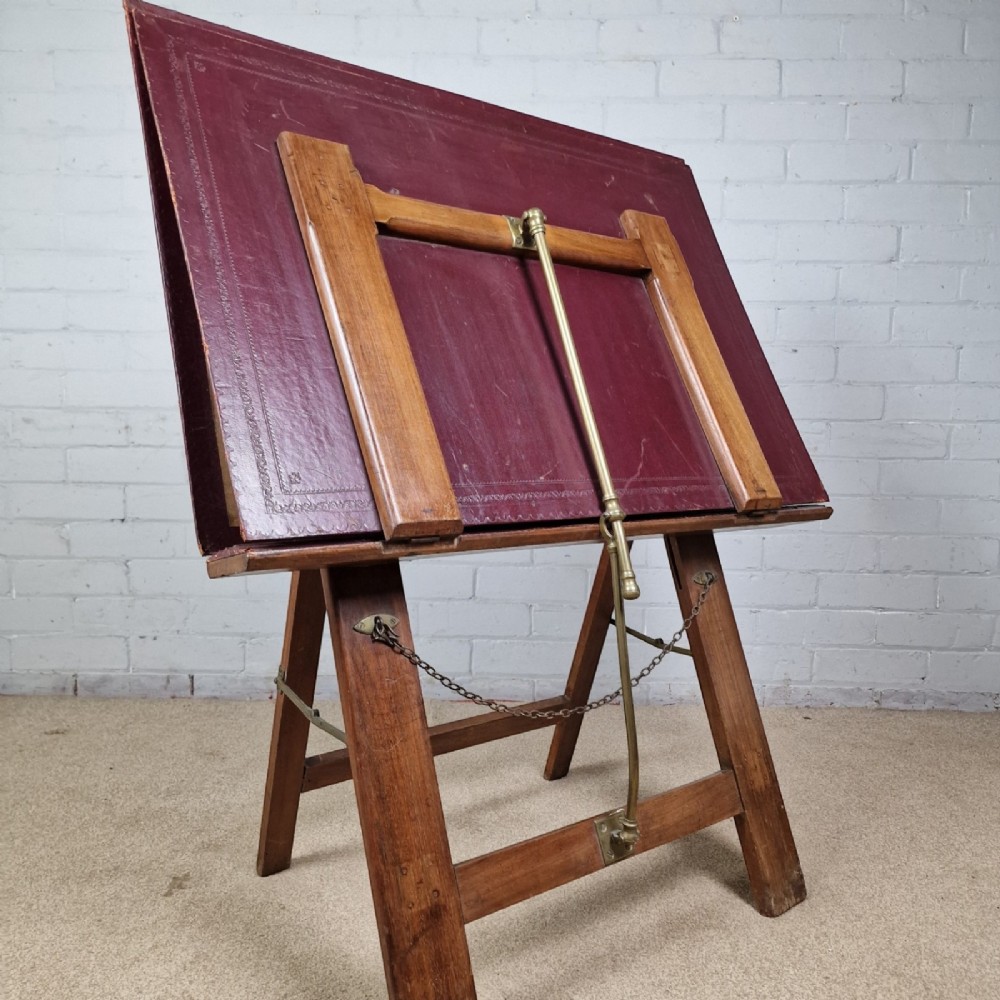 A late 19th-century mahogany folio stand with burgundy leather panels, an adjustable brass ratchet arm, and a wooden trestle frame. View V