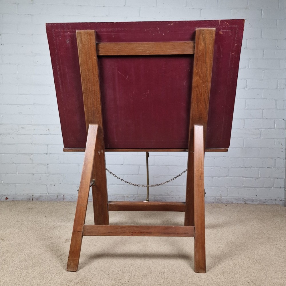 A late 19th-century mahogany folio stand with burgundy leather panels, an adjustable brass ratchet arm, and a wooden trestle frame. View VI