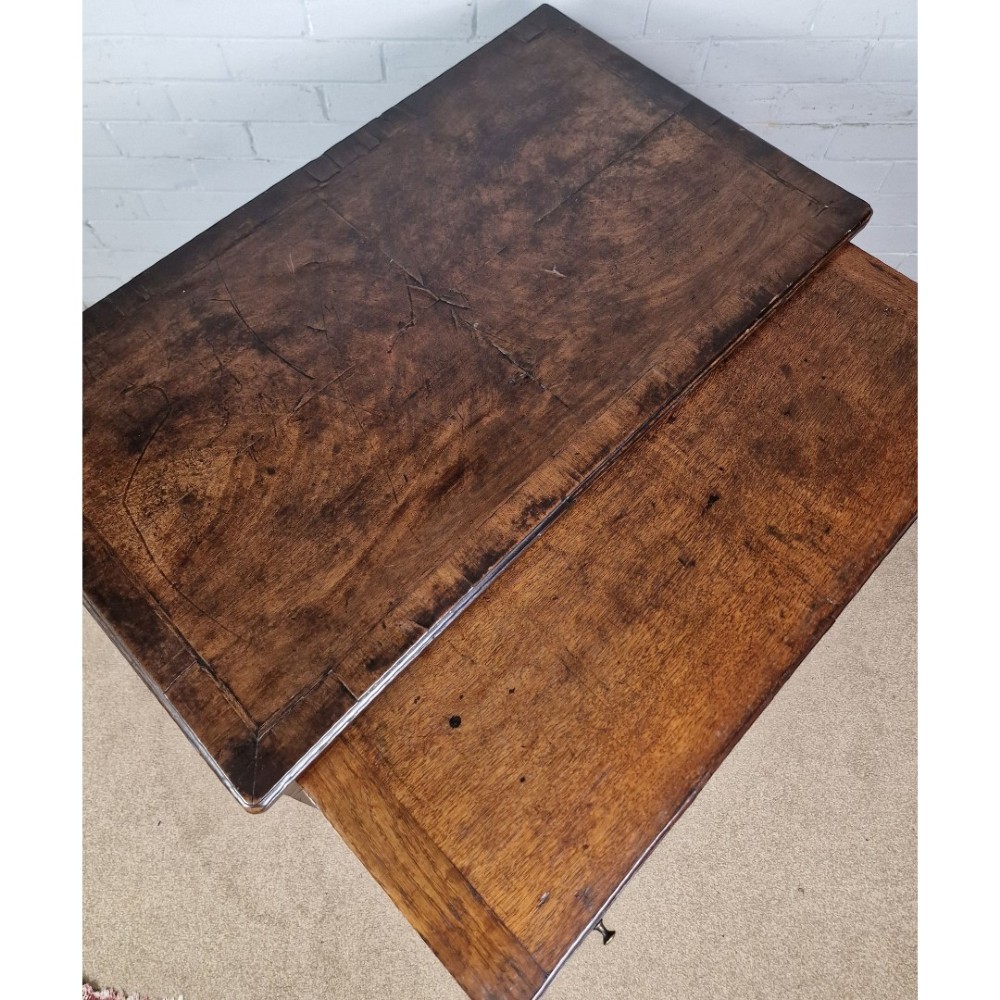 An early Georgian warm brown walnut kneehole desk featuring brass drop handles, side drawers, a central recessed cupboard, and bracket feet. View VII