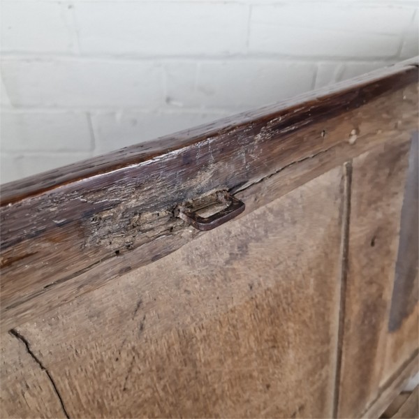 A seventeenth-century dark oak joined coffer featuring a carved central floral panel, a geometric top frieze, and a panelled front facade. View VII