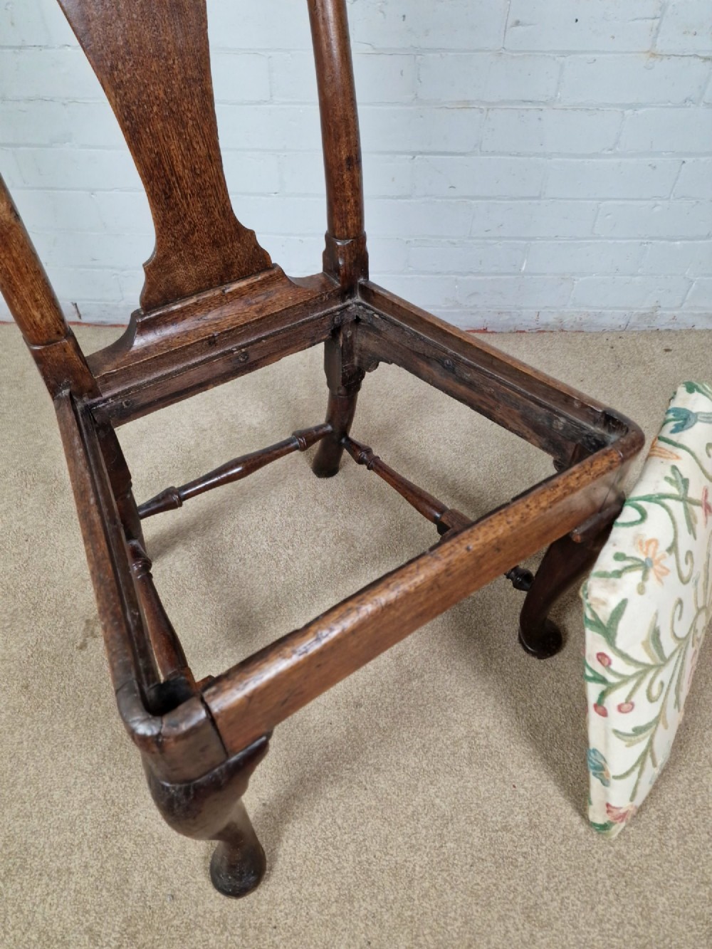 An early 18th century Queen Anne wooden dining chair featuring cabriole front legs, a vasiform back splat, and a patterned drop-in seat cushion. View VI