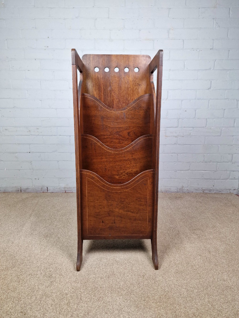 A tall Arts and Crafts brown oak magazine rack featuring three tiered compartments, circular cut-out details at the top, and integrated side carry handles. View II