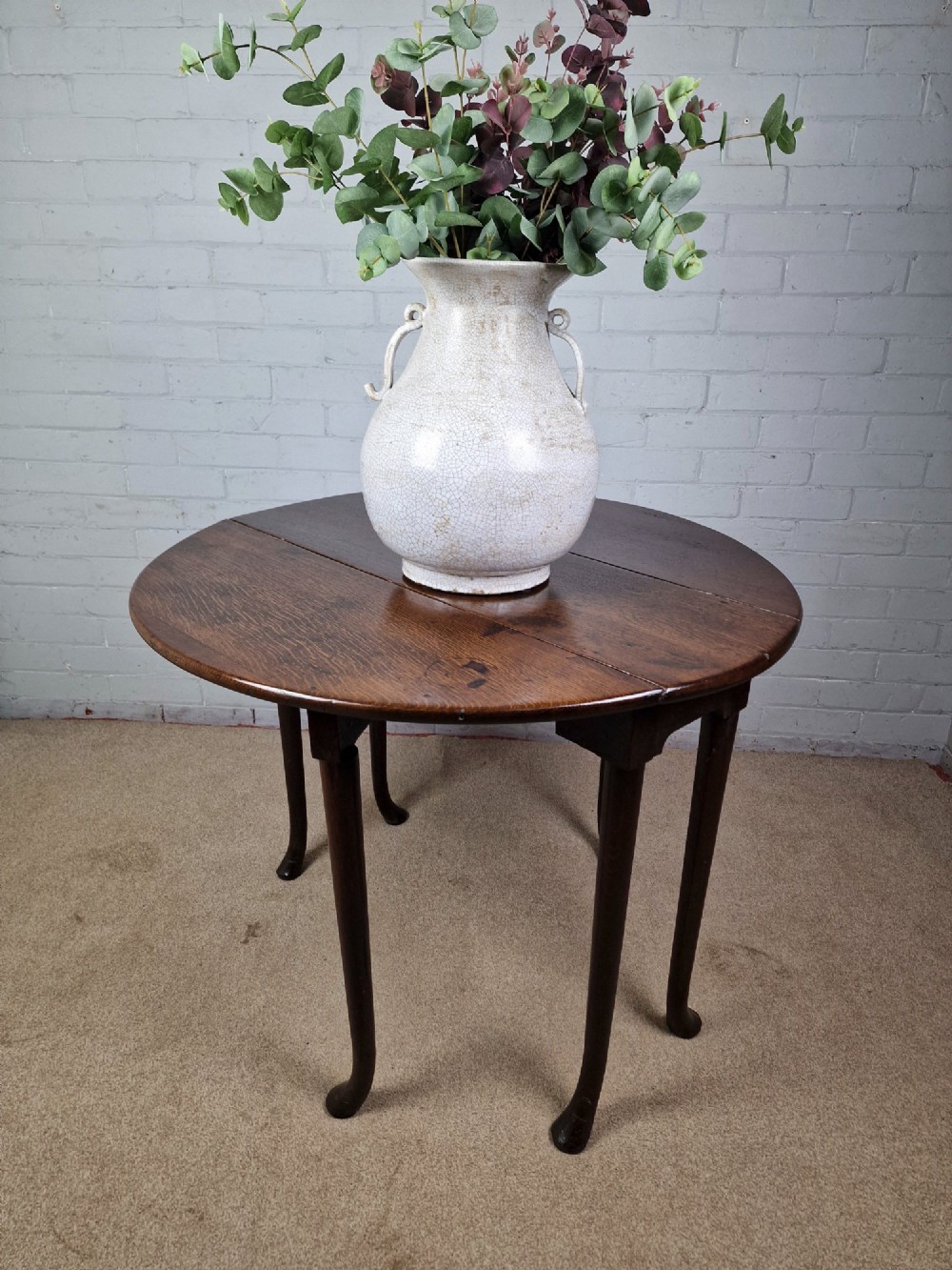 An 18th-century Georgian dark oak gateleg table with hinged leaves and slender tapered legs ending in pad feet. View VII