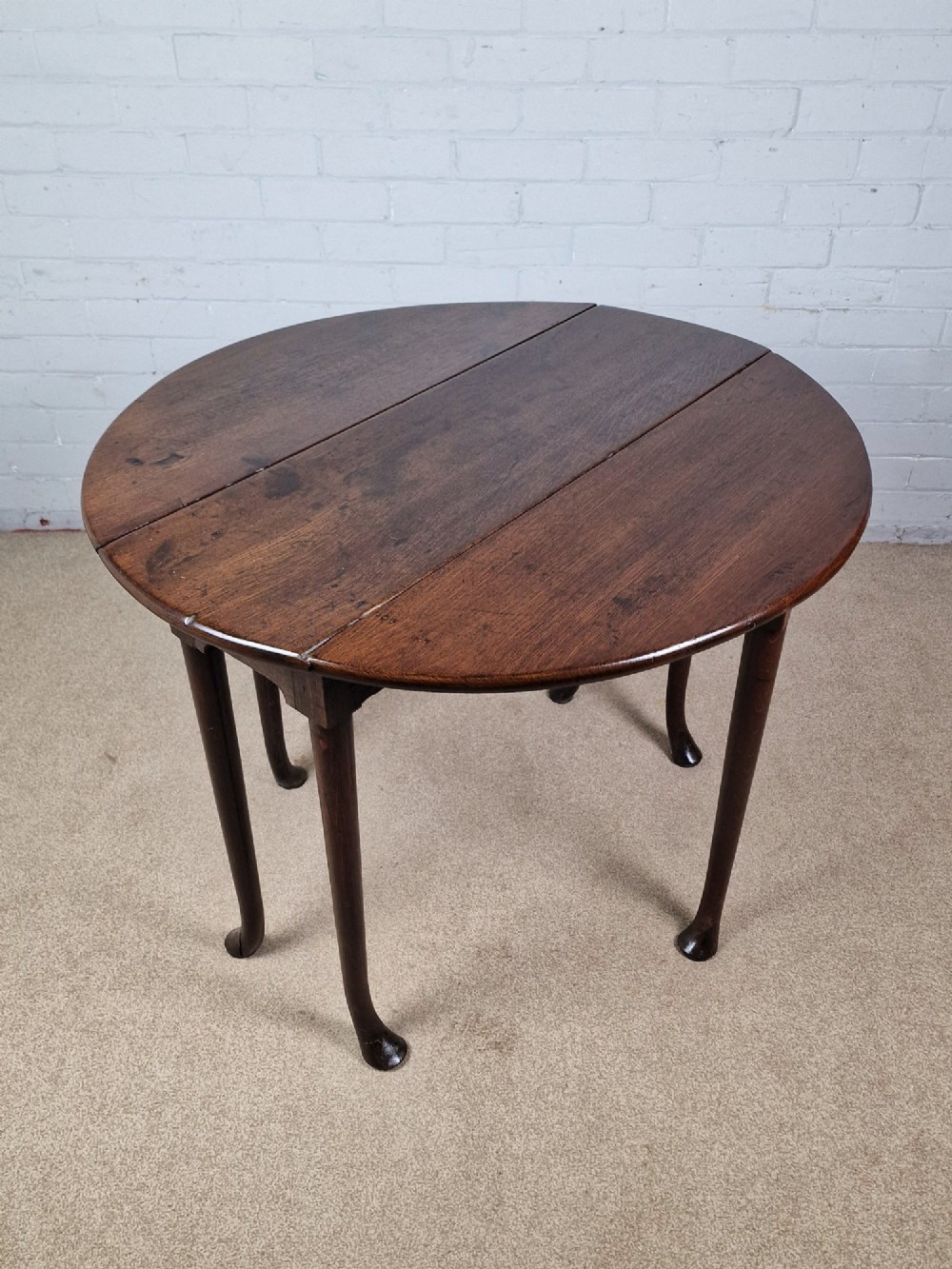 An 18th-century Georgian dark oak gateleg table with hinged leaves and slender tapered legs ending in pad feet. View VIII