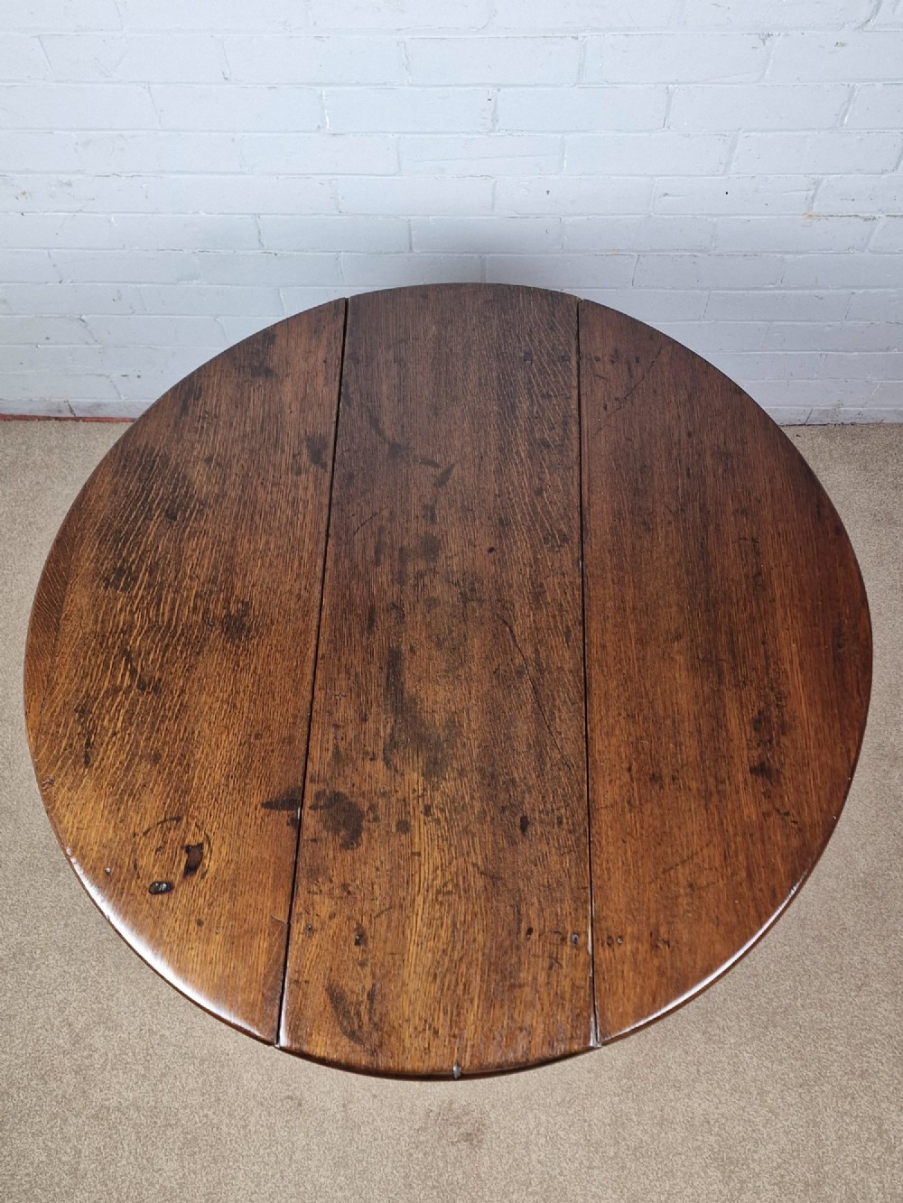 An 18th-century Georgian dark oak gateleg table with hinged leaves and slender tapered legs ending in pad feet. View X