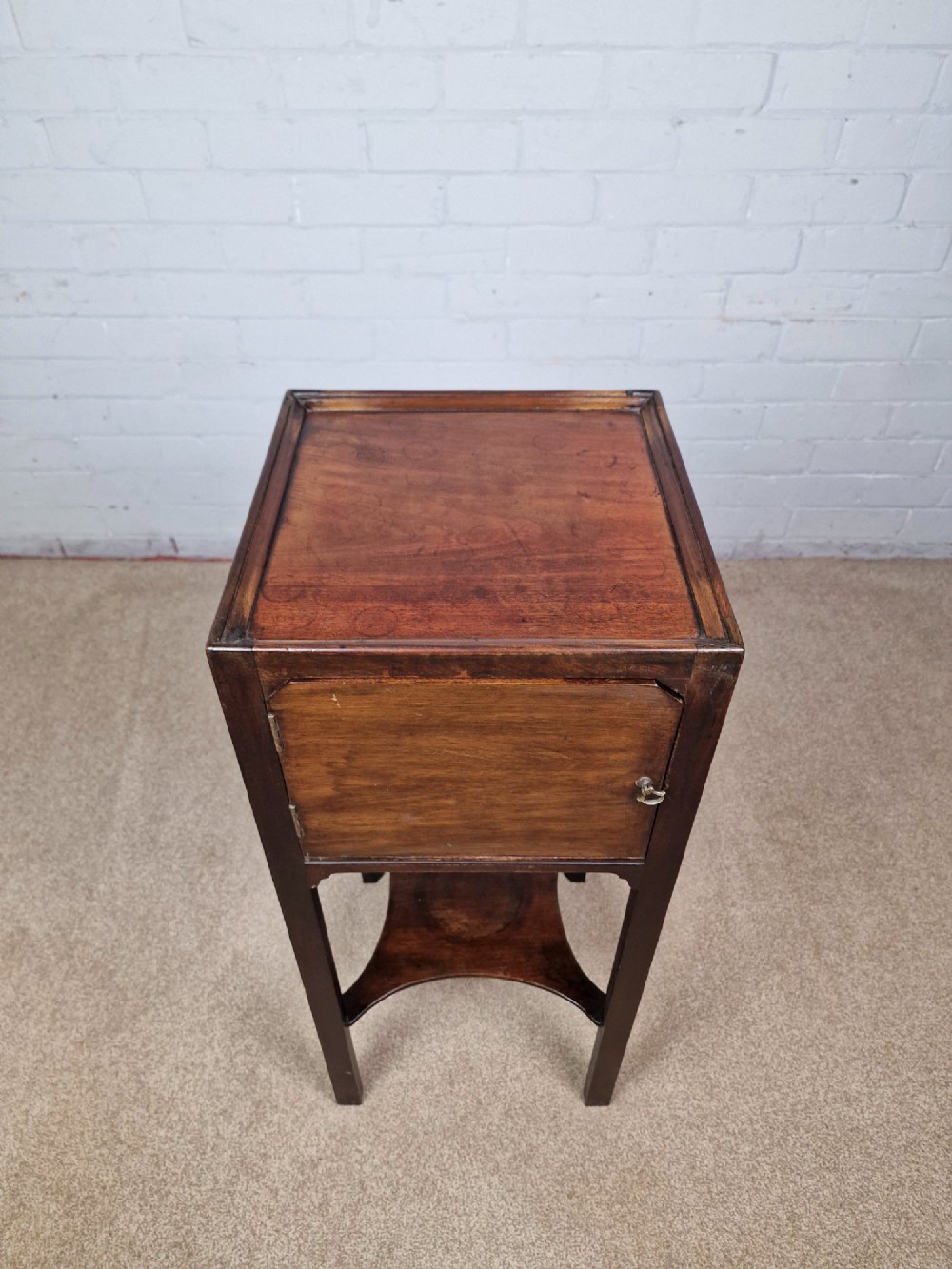 A tall Georgian dark mahogany bedside cabinet with a single door cupboard, straight legs, and an arched lower X-stretcher shelf. View II