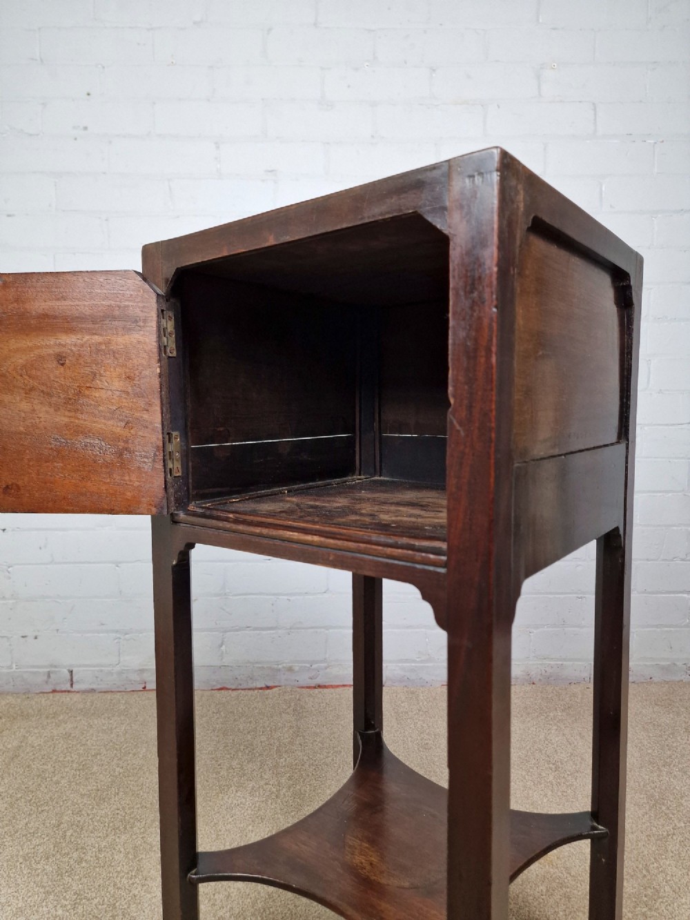 A tall Georgian dark mahogany bedside cabinet with a single door cupboard, straight legs, and an arched lower X-stretcher shelf. View VII