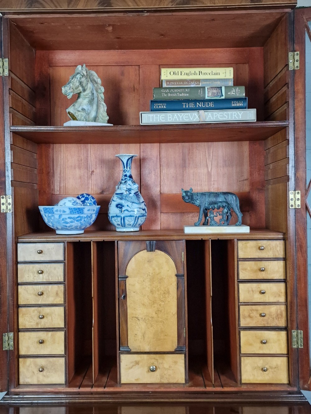 A George III mahogany secretaire bookcase featuring geometric astragal glazed upper doors above a lower chest of drawers with brass drop handles and bracket feet. View II