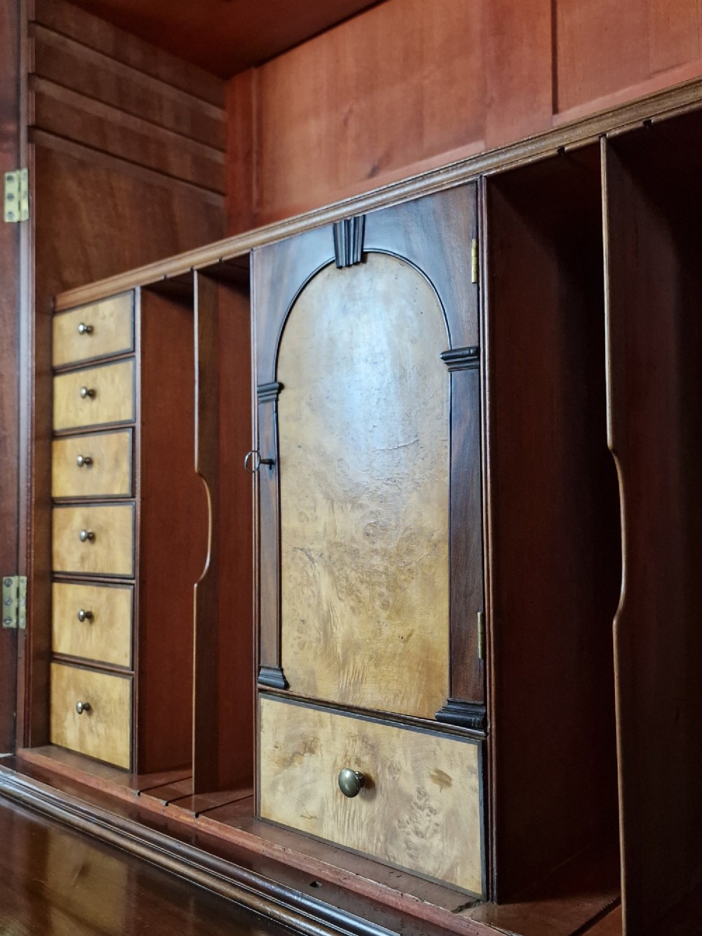 A George III mahogany secretaire bookcase featuring geometric astragal glazed upper doors above a lower chest of drawers with brass drop handles and bracket feet. View VI