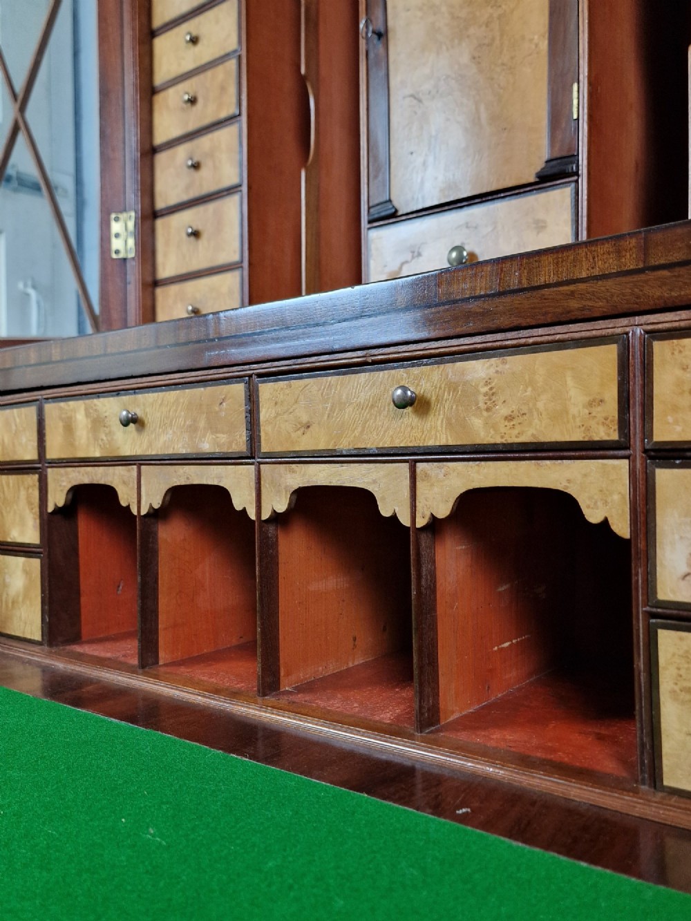 A George III mahogany secretaire bookcase featuring geometric astragal glazed upper doors above a lower chest of drawers with brass drop handles and bracket feet. View VII