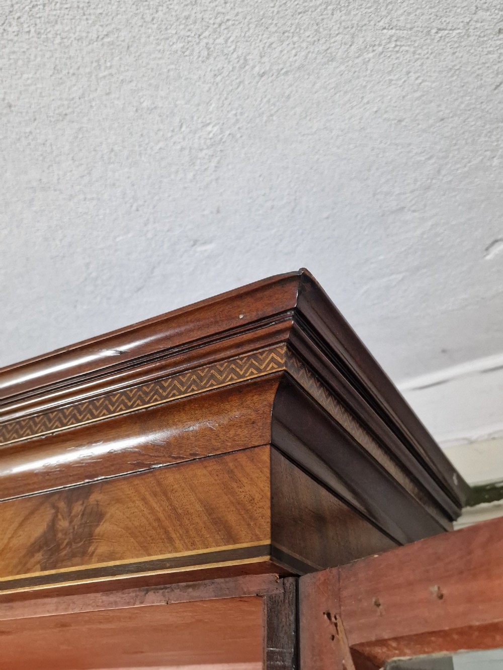 A George III mahogany secretaire bookcase featuring geometric astragal glazed upper doors above a lower chest of drawers with brass drop handles and bracket feet. View VIII