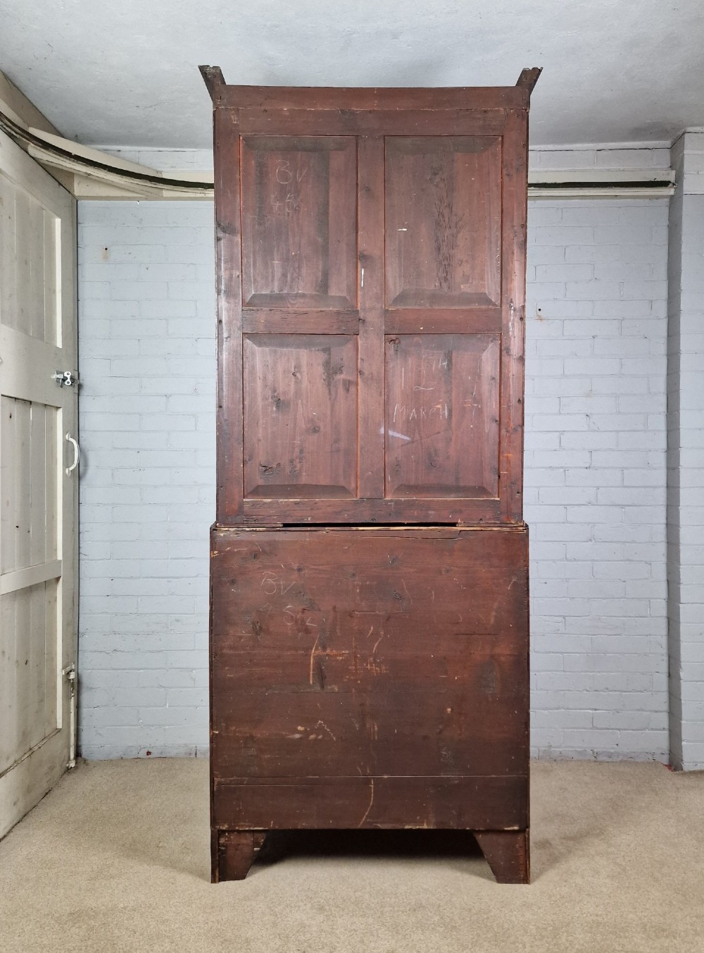 A George III mahogany secretaire bookcase featuring geometric astragal glazed upper doors above a lower chest of drawers with brass drop handles and bracket feet. View XIII