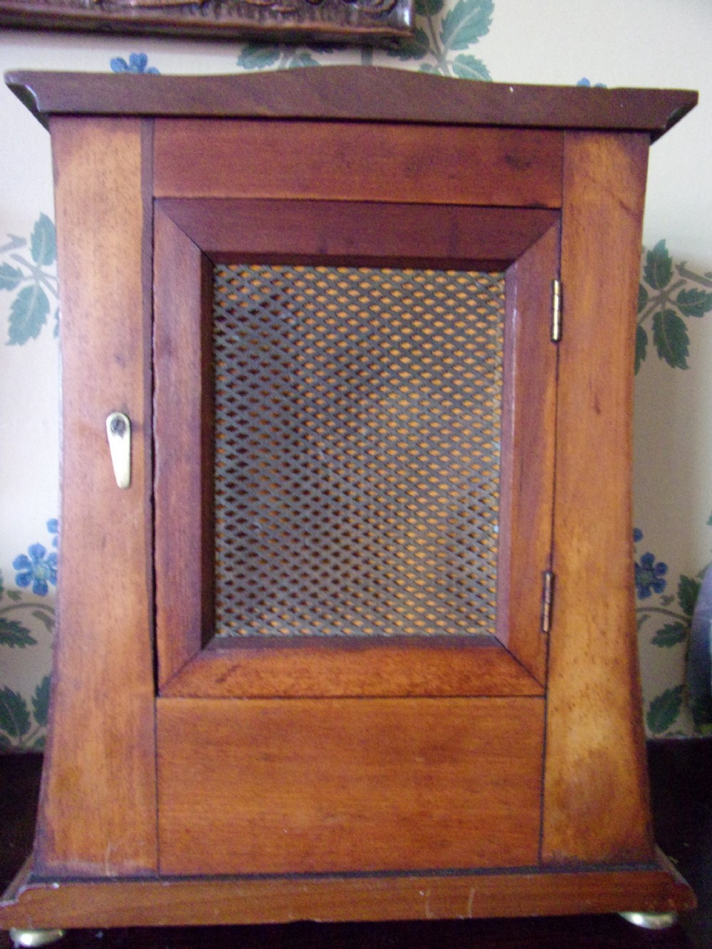 An Arts and Crafts Edwardian mahogany mantel clock featuring geometric line inlay, a circular white dial with Arabic numerals, and brass bun feet. View IV