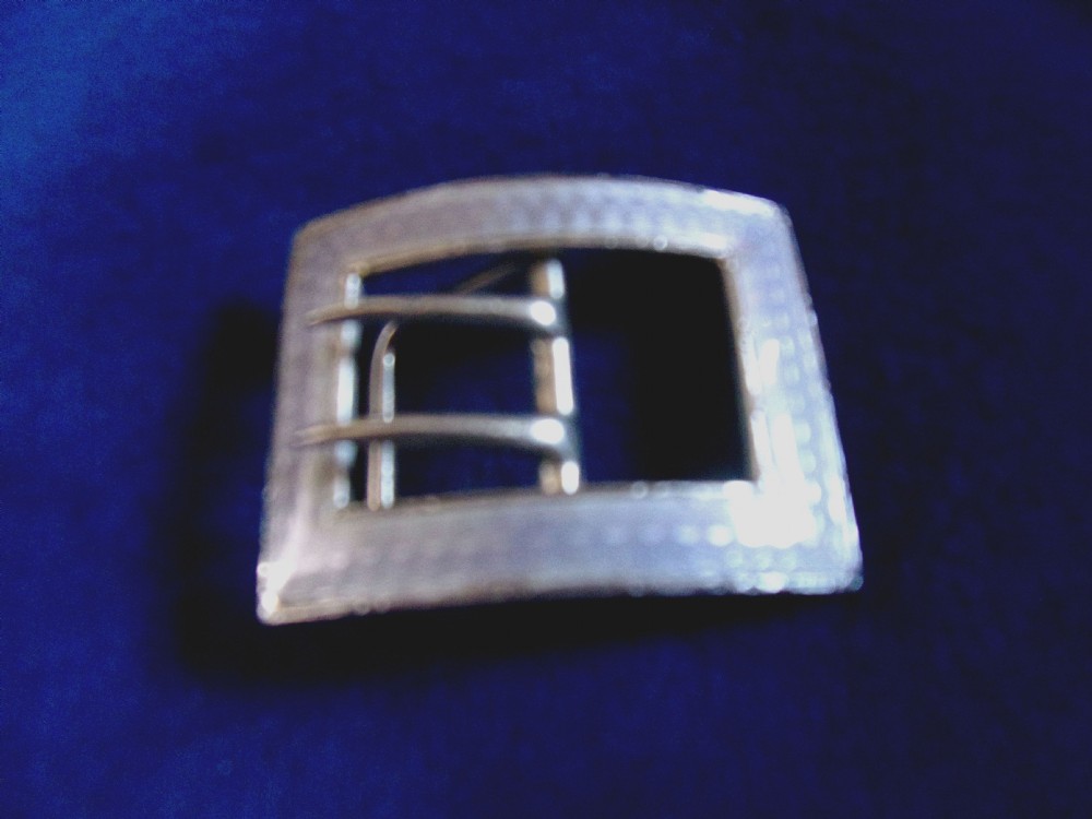 An Edwardian sterling silver and enamel belt buckle featuring a curved rectangular shape with internal double prongs.