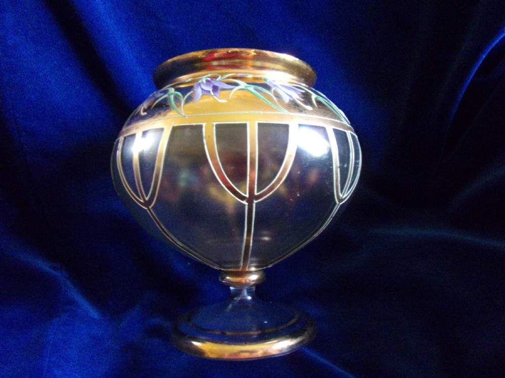 An Art Nouveau footed glass vase featuring a wide gilded collar, hand-painted purple enamel bellflowers, green foliage, and geometric lower panelling. View II
