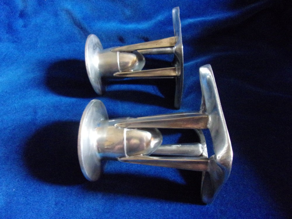 A pair of Arts and Crafts pewter candlesticks featuring square bases, four upright tapered struts, and bulbous candle sockets with flat drip rims. View II