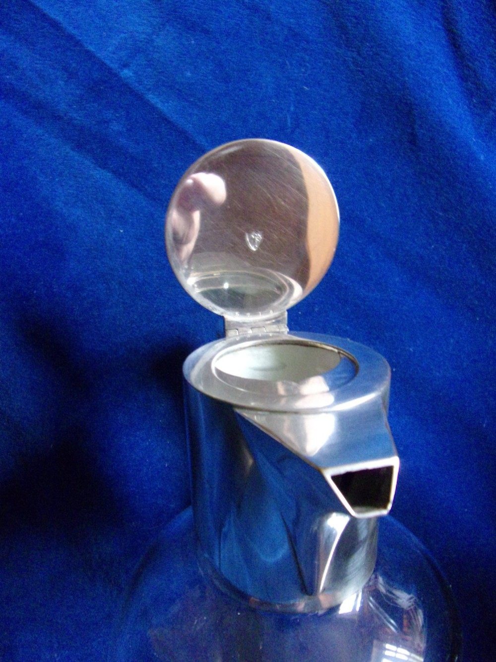 An Arts and Crafts clear glass claret jug featuring a silver-plated hinged collar, angular handle, and flat lid. View IV