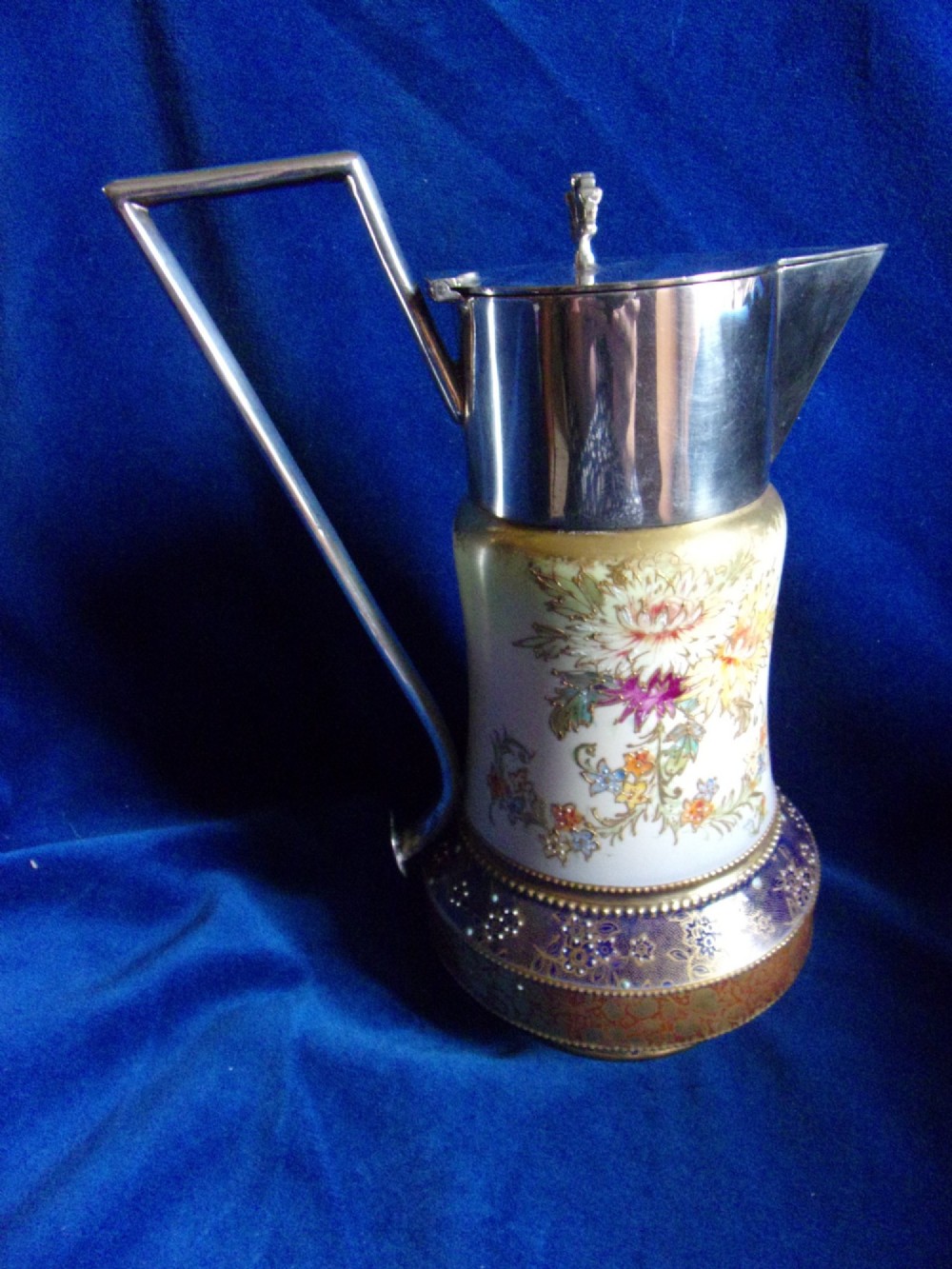 An antique Carlton Ware ceramic claret jug featuring floral enamel detailing and a polished silver-plated neck, lid, and geometric handle. View III