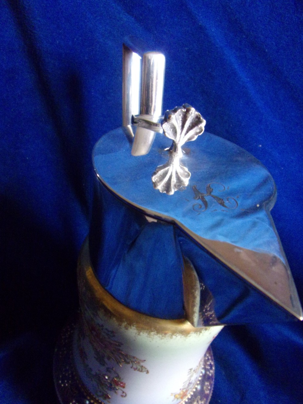 An antique Carlton Ware ceramic claret jug featuring floral enamel detailing and a polished silver-plated neck, lid, and geometric handle. View VI