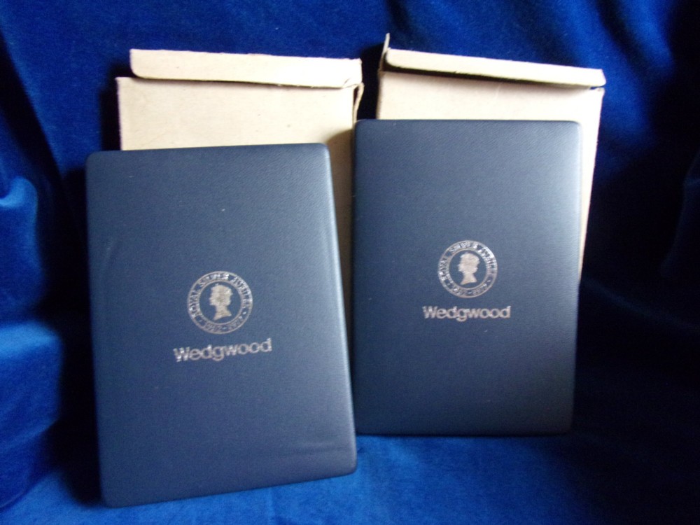A pair of framed oval Wedgwood blue and white jasperware medallions depicting profile portraits of Queen Elizabeth II and Prince Philip in dark presentation boxes. View V