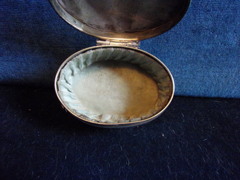 An oval sterling silver trinket box with a smooth polished lid resting on four slender cabriole feet. View VI