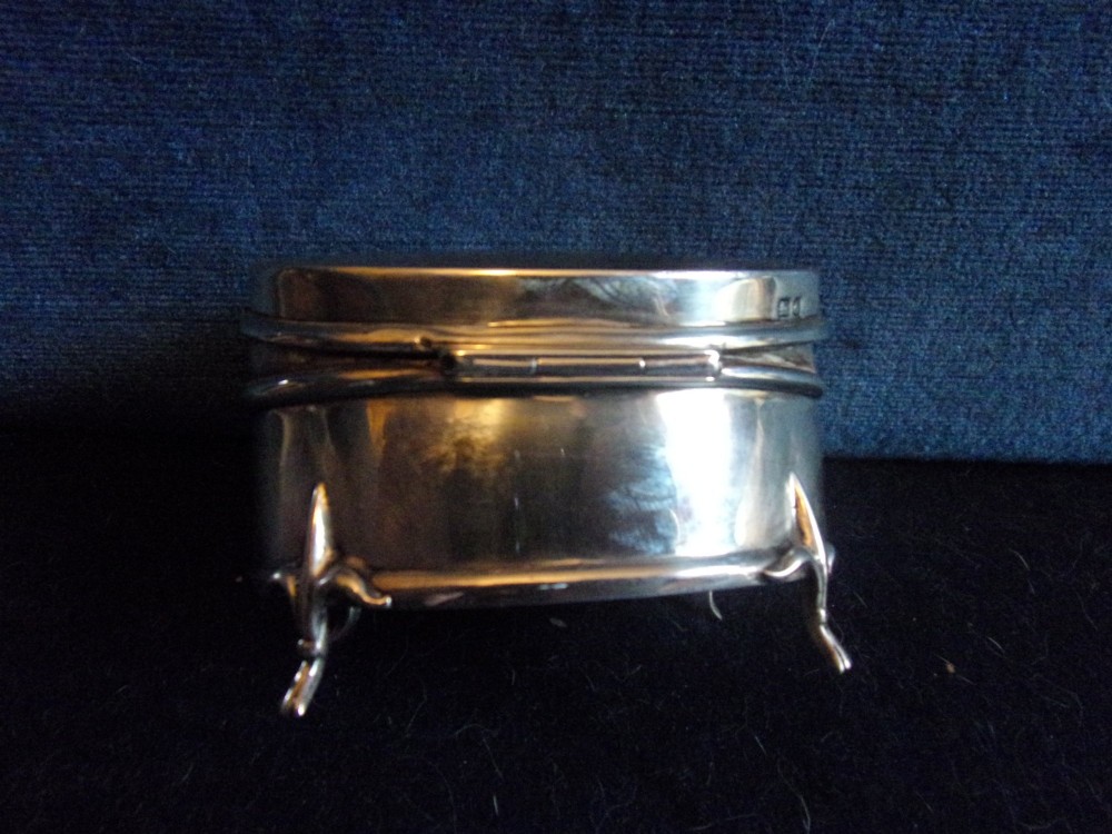 An oval sterling silver trinket box with a smooth polished lid resting on four slender cabriole feet. View VIII